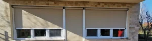 Kőburkolatos terasz nagyméretű ablakain és ajtaján leengedett modern, bézs színű külső textil árnyékolók